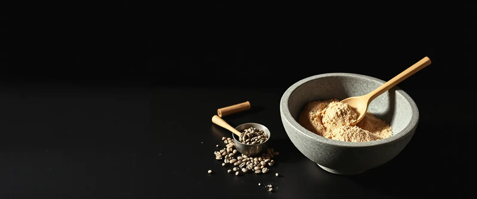 A wide stone bowl of fine tea powder with a bamboo whisk lying beside it.